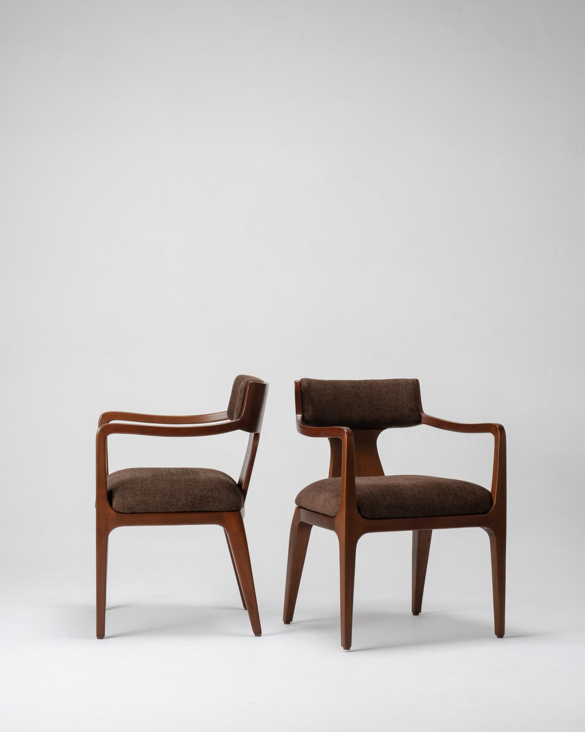 Pair of brown chairs with wooden frames on a white background, dark brown colour