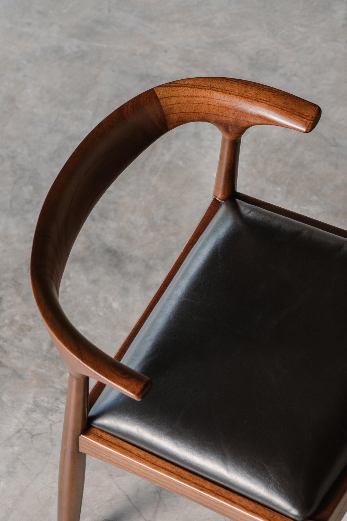 Chair with wooden armrests and black leather seat