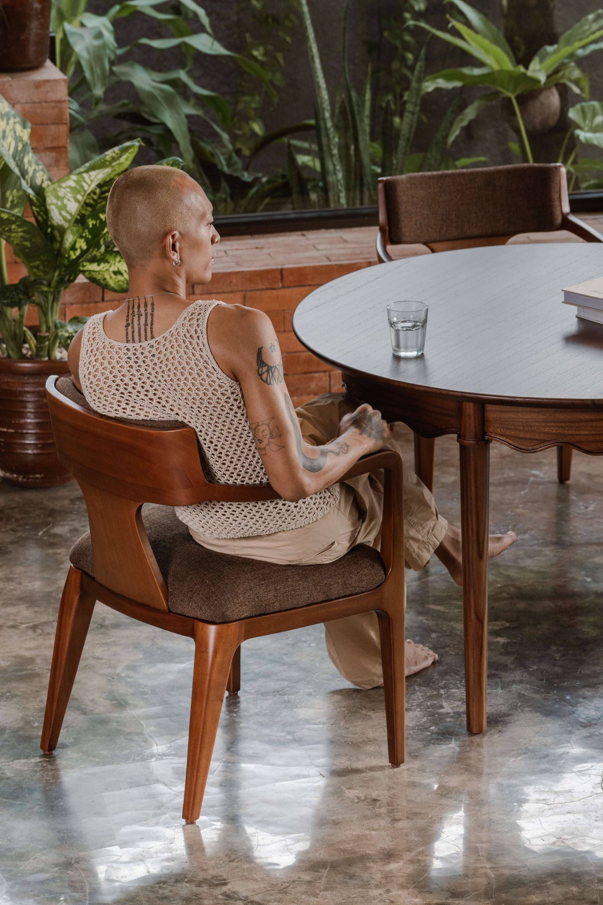 dining chair with arm, upholstered back and seat, in front of round dining table